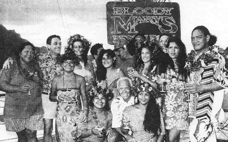 Dexter Hewett posing with longtime Bloody Mary's team inside the lantern-lit bamboo restaurant hall