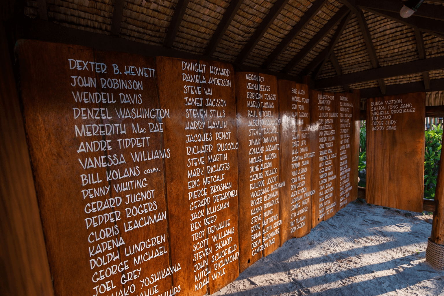 Hand-painted illustrated welcome board lettering Bloody Mary's Hotel amidst tropical foliage